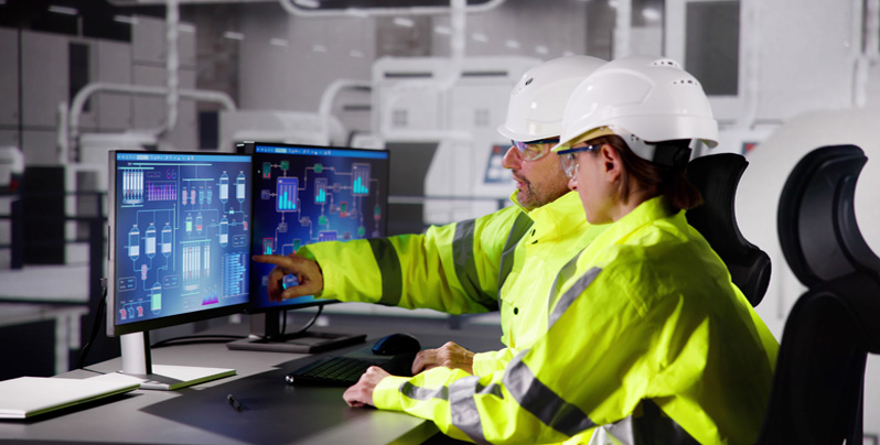 Pareja de trabajadores observando pantalla de ordenador Pareja de trabajadores observando pantalla de ordenador